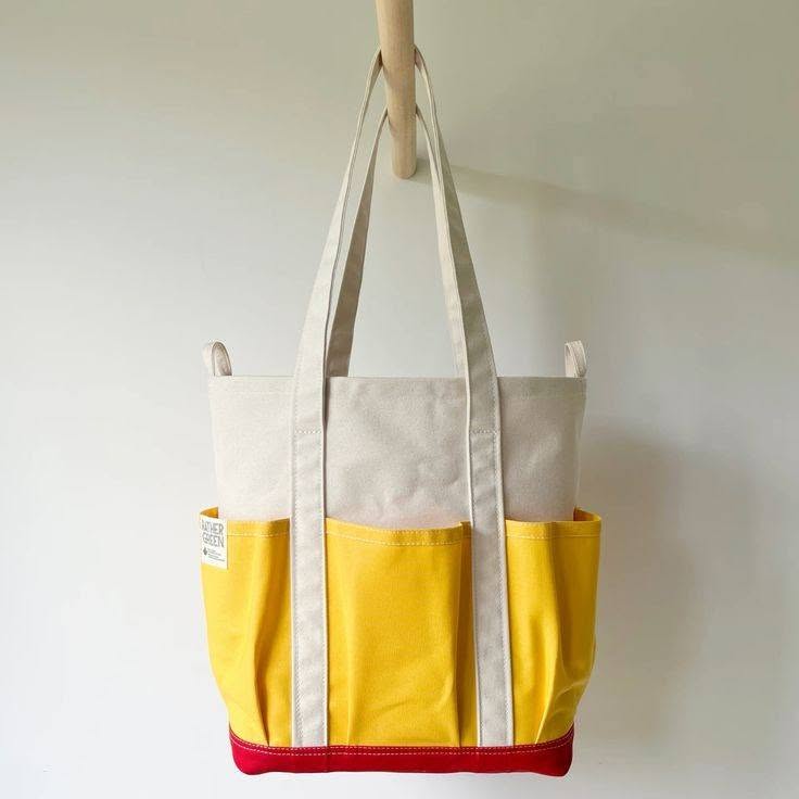 Cream, yellow and red canvas tote bag with exterior pockets